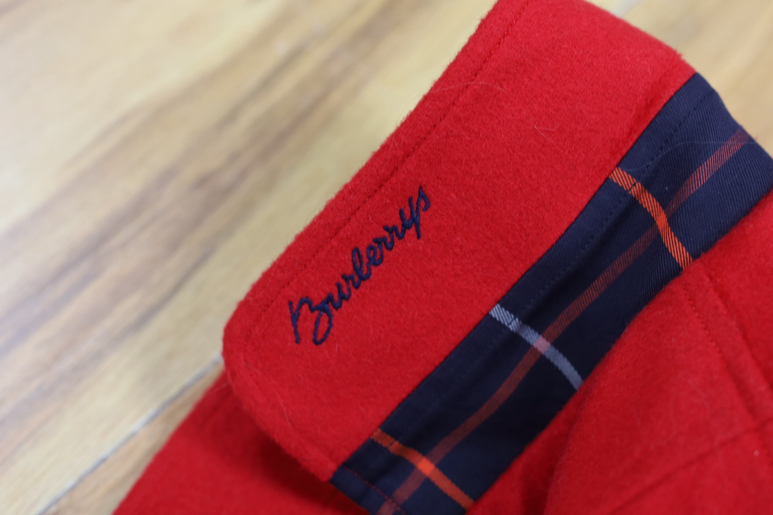 Two vintage Burberry items of clothing: a pleated skirt and a red Harrington jacket